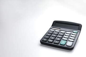 A black calculator with large buttons is placed on a white surface.