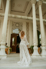  Beautiful slim blonde poses in boho wedding dresses and an embroidered corset on a summer terrace.