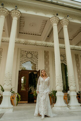  Beautiful slim blonde poses in boho wedding dresses and an embroidered corset on a summer terrace.