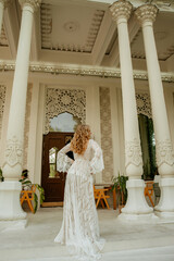  Beautiful slim blonde poses in boho wedding dresses and an embroidered corset on a summer terrace.