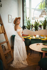  Beautiful slim blonde poses in boho wedding dresses and an embroidered corset on a summer terrace.