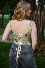 Beautiful slim blonde poses in boho wedding dresses and an embroidered corset on a summer terrace.