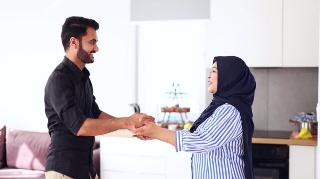 Happy Muslim couple in the kitchen of their home 
