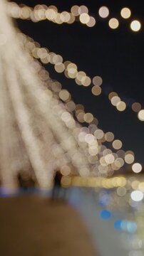 Vertical Screen: Holiday background with bridge in parck at the Christmas market. Out of focus holiday background. Light bokeh from Xmas tree. New Year theme, background.