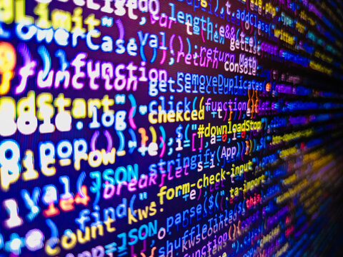 Simple website HTML code with colorful tags in browser view on dark background. HTML5 concept macro backdrop in warm colors