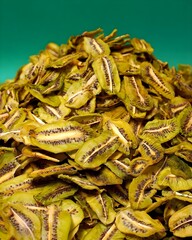Dried Green Kiwi Slices on Green Background