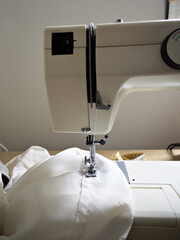 Elegant sewing composition featuring a retro sewing machine carrying a soft, white fabric.