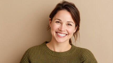 Cheerful Young Woman Smiling Against a Neutral Background in Cozy Sweater