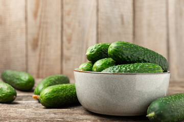 Cucumber on wooden background. Slice of cucumber on background. Fresh organic green cucumbers gherkin. Vegan. Salad ingredient. Farm vegetables. Cut vegetables with knife. Space for text. Copy space