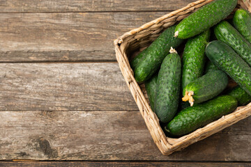 Cucumber on wooden background. Slice of cucumber on background. Fresh organic green cucumbers gherkin. Vegan. Salad ingredient. Farm vegetables. Cut vegetables with knife. Space for text. Copy space