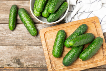 Cucumber on wooden background. Slice of cucumber on background. Fresh organic green cucumbers gherkin. Vegan. Salad ingredient. Farm vegetables. Cut vegetables with knife. Space for text. Copy space