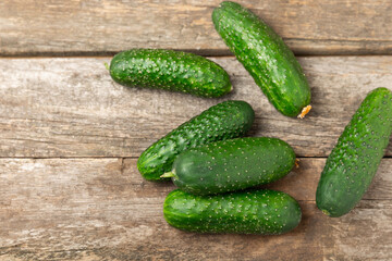 Cucumber on wooden background. Slice of cucumber on background. Fresh organic green cucumbers gherkin. Vegan. Salad ingredient. Farm vegetables. Cut vegetables with knife. Space for text. Copy space