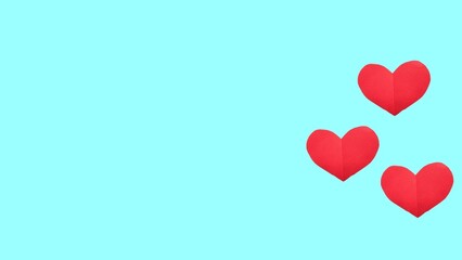 Red paper hearts of various size lying on pastel blue background. Valentines Day, love and feelings concept, top view, copy space