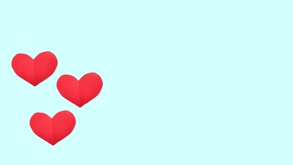 Red paper hearts of various size lying on pastel blue background. Valentines Day, love and feelings concept, top view, copy space