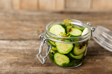 Freshly-salted homemade cucumbers in a jar on a wooden background. pickled cucumbers with dill,garlic and pepper.canned cucumbers.cucumbers and dill.Recipe of homemade preservations.fermented veggies.