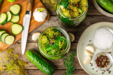 Freshly-salted homemade cucumbers in a jar on a wooden background. pickled cucumbers with dill,garlic and pepper.canned cucumbers.cucumbers and dill.Recipe of homemade preservations.fermented veggies.