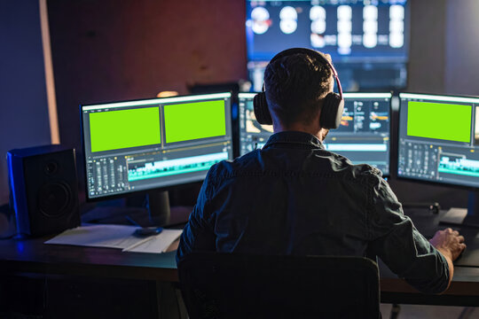 A man is editing a commercial video on a computer in a studio.