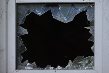 Broken window glass with jagged edges in a frame. Shattered glass design, copy space. Security, architecture, repair industries. Structural vulnerability and material failure in construction contexts