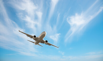 White passenger airplane flying in the sky amazing clouds in the background - Travel by air transport
