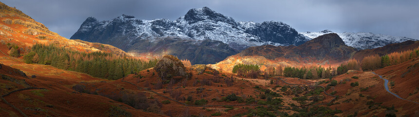Panoramic view of The Langdale Pikes snowcapped mountains on a autumn morning in The Lake District, UK.