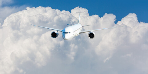 White passenger airplane flying in the sky amazing clouds in the background - Travel by air transport