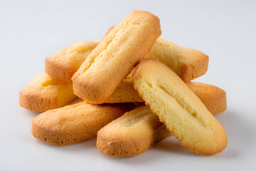 Fototapeta premium Golden Italian savoiardi biscuits stacked on light background, perfect for dessert recipes, coffee pairing, and bakery promotions.