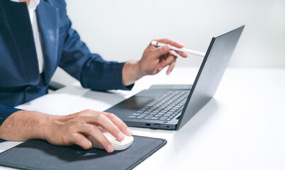 Business man  using a laptop and a cell phone at the same time.