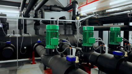 Fototapeta premium Industrial pumps operating in modern facility with complex pipe system