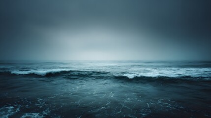Vast, moody ocean waves under a cloudy sky.