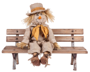 Scarecrow doll with straw hat, orange scarf, and burlap clothing sitting on rustic wooden bench, cheerful expression, autumn harvest decoration, isolated on transparency background