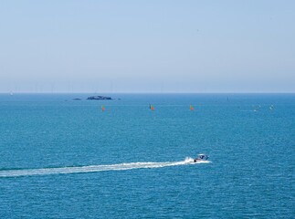 Un bateau hors-bord navigue sur l'océan Atlantique en été par temps ensoleillé, avec tons plus vifs