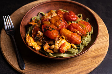 Delicious pasta dish with roasted tomatoes and chicken served in a rustic bowl
