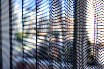 Close-up texture of mosquito net screen. Fine metal mesh, insect protection, and window detail.