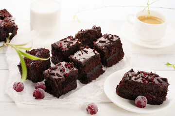 Delicious chocolate brownies served with fresh berries and coffee on a white table