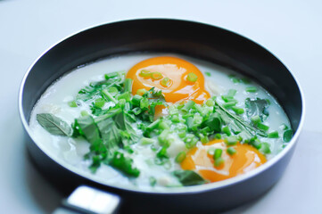 fried egg or sunny side up egg with vegetable topping before fry