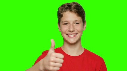 Smiling Young Boy Giving Thumbs Up on Green Screen. Cheerful Male Kid with Wavy Hair Shows Approval, Happiness, and Success. Ideal for Easy Keying, Stock Footage, Education, and Advertising