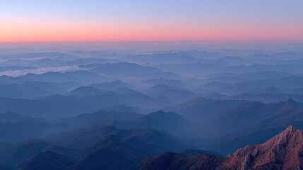 Layered mountains in misty morning light with pink sky