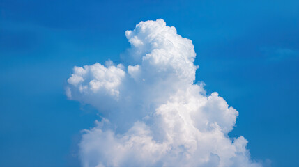 Fluffy cumulus cloud against a clear blue sky, creating a serene summer atmosphere.