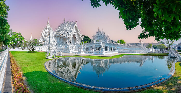 Stunning white temple wat rong khun reflected in tranquil pond in Chiang Rai panorama, Thailand amazing landmark