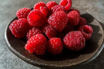 raspberries in a black dish