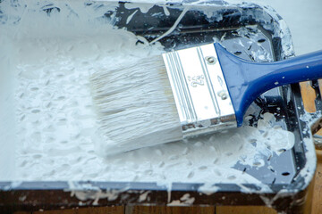 Photo of painting with white paint on wood. Interior painting. Making repairs, painting. White paint © Елена Загорий