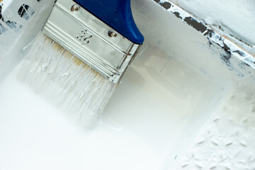 Photo of painting with white paint on wood. Interior painting. Making repairs, painting. White paint