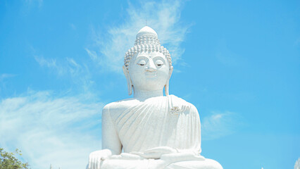 Phuket Big Buddha statue. afternoon light sky and blue ocean are on the back of white Phuket big Buddha is the one of landmarks on Phuket island Thailand.