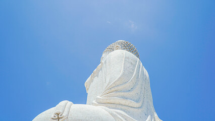 Phuket Big Buddha statue. afternoon light sky and blue ocean are on the back of white Phuket big Buddha is the one of landmarks on Phuket island Thailand.