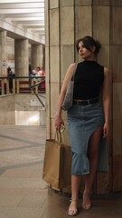 Beautiful brunette stands at the metro station waiting for the train to arrive