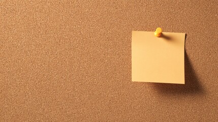 An orange yellow sticky note pinned to a brown corkboard in the foreground,