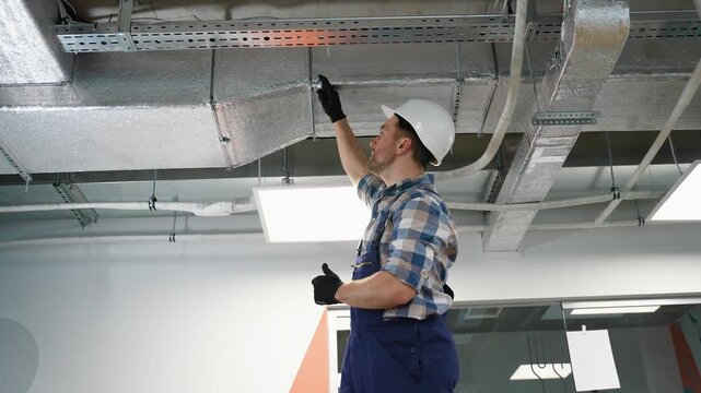 Hvac technician inspecting air ducts in a building