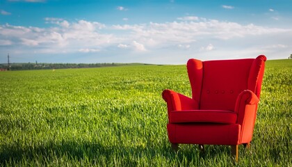 Fototapeta premium vibrant red chair in a tranquil green field peaceful outdoor scene red