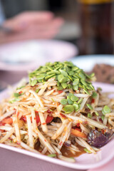 Papaya salad with crab and fermented fish topped with raw peel acacia seeds. Thai food