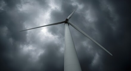 Low-angle shot of a towering wind turbine against a dramatic sky &mdash; renewable energy theme, strong perspective